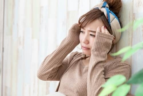 頭痛の辛い症状で眠れずに悩む女性